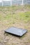 Vertical shot of a broken TV dumped in a grassy field during daytime