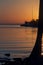 Vertical shot of calm waters near a dock with a colorful sunset sky background