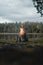 Vertical shot of a campfire surrounded by greenery under a cloudy sky in the morning