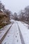 Vertical shot of car tracks and shoe steps on the snowy road of Gipuzkoa\\\'s mount Aizkorri