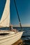 Vertical shot of carefree retired man enjoying amazing view and relaxing while sitting on the side of his sailboat or