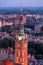 Vertical shot of the cathedral spire and tiled roofs of Gdansk at sunset
