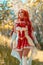 Vertical shot of a Caucasian female in miss fortune cosplay costume walking in the woods