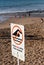 Vertical shot of the caution sign in the sandy beach