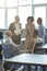 Vertical shot of cheerful multiracial business people having a meeting in the modern office, discussing work and smiling