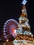 Vertical shot of a Christmas tree and a Ferris Wheel in Maastricht, the Netherlands at night