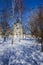 Vertical shot of a church obstructed by trees during winter in a park near Yauza River, Moscow