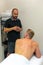 Vertical shot of a client explaining back and neck pain to the physiotherapist and sports osteopath