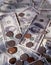 Vertical shot of coins on hundred dollar bills