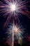 Vertical shot of colorful dazzling fireworks over a house in the night sky