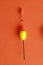 Vertical shot of a colorful fishing rod bobber on an orange background