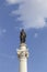 Vertical shot of the Column of Pedro IV monument in Lisbon, Portugal against a cloudy blue sky