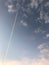 Vertical shot of the contrail of an airplane surrounded by clouds