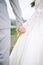 Vertical shot of a couple in marriage suits romantically holding  each other`s hands