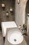 Vertical shot of a cozy comfortable bathroom with a stylish modern sink, faucet, large bath, grey stone walls and wall flower pots