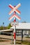 Vertical shot of cross signs with [Se efter tog - look after train] written under it on the road