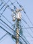 Vertical shot of a crowded electrical pole with cords on a clear blue sky background