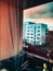 Vertical shot of curtains reflection on the window and view of the outdoor buildings