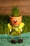 Vertical shot of a cute figurine pot with growing grass