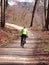 Vertical shot of a cycler riding a bike in an autumn forest