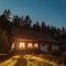 Vertical shot of dazzling light in a cottage on a hill during nighttime