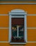 Vertical shot of a decorated window of a house of a yellow building in Targu Mures, Romania