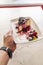 Vertical shot of a delectable slice of burnt cheesecake with berries being served at a restaurant