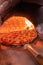 Vertical shot of a delicious cheesy pepperoni pizza inside the brick stone oven