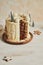 Vertical shot of a delicious layered Christmas drip cake on a wooden plate