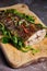 Vertical shot of delicious seasoned fish on a wooden plate