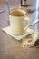 Vertical shot of dollar bills placed next to an empty coffee glass