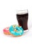 Vertical shot of donuts and a glass of coke on a white surface