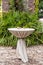 Vertical shot of an elegant outdoor tall table with green plants in the background