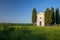 A vertical shot of the famous historic Chapel Vitaleta in the middle of a field in Italy