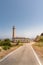 Vertical shot of the Faro Punta Carnero lighthouse near a road in Spain