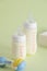 Vertical shot of feeding bottles with baby food, baby rattle and disposable towels