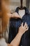 Vertical shot of a female fixing a blue striped shirt on a mannequin