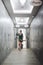 Vertical shot of a female in a nice dress walking in a beautiful hallway