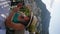 Vertical shot of female tourist in hat and sunglasses using smartphone in Amalfi coast, taking photo, shooting video