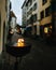 Vertical shot of a fire flame coming out from a metal cauldron in the street against blur background