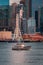 Vertical shot of a fishing vessel leaving Pier 57 in front of many glassy skyscrapers in Elliot Bay