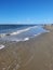 Vertical shot of the foamy waves of the North Sea hitting the sandy beach in St. Peter-Ording