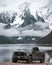 Vertical shot of a Ford F-150 at shore of a lake on the background of mesmerizing snowy mountains