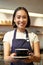 Vertical shot of friendly asian girl smiling, serving coffee, barista giving you cup of coffee, prepared drink for