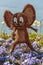 Vertical shot of a funny mouse figurine in a flower garden