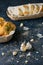 Vertical shot of garlic cloves and herbed bread on a gray table