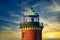 Vertical shot of a giant lighthouse gleaming under the cloudy sky