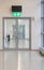 Vertical shot of a glass door and an emergency exit sign above the door