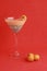 Vertical shot of a glass of fruity dessert isolated on a red surface