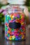 Vertical shot of a glass jar filled with colorful jelly beans